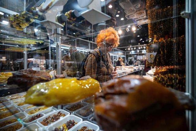 A customer looks at a selection of amber necklaces at a vendor's stall at the Amberif fair in Gdansk, on March 26, 2026. Around 200 exhibitors take part in this year’s Amberif, a fair held annually in Gdansk where entrepreneurs, craftsmen and artists from all over the world who work with amber can sell or buy amber, establish new contracts or simply showcase their offerings. (Photo by Wojtek RADWANSKI / AFP)