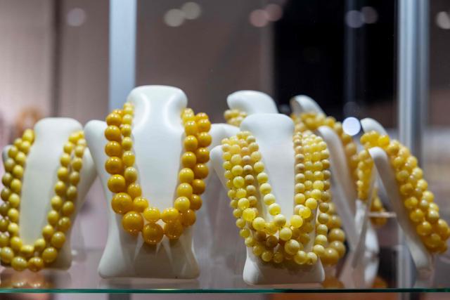 This photo taken on March 26, 2026 shows necklaces made of Baltic amber displayed at the Amberif Fair in Gdansk. Around 200 exhibitors take part in this year’s Amberif, a fair held annually in Gdansk where entrepreneurs, craftsmen and artists from all over the world who work with amber can sell or buy amber, establish new contracts or simply showcase their offerings. (Photo by Wojtek RADWANSKI / AFP)