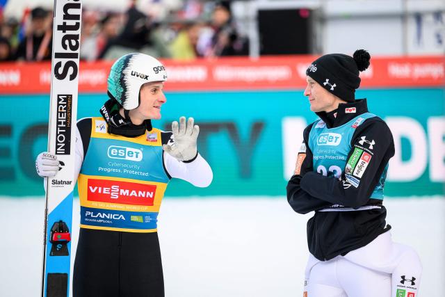 Slovenia’s Domen Prevc (L) speaks with Anze Lanisek during the second round of the Men Individual Flying Hill competition of the FIS Ski Jumping World Cup in Planica, Slovenia on March 27, 2026. (Photo by Jure Makovec / AFP)