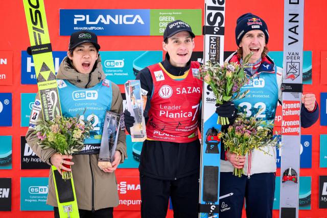 (From L) Second placed Japan’s Ren Nikaido, winner Slovenia’s Domen Prevc and third placed Austria’s Daniel Tschofenig pose for photos on the podium of the Men Individual Flying Hill competition of the FIS Ski Jumping World Cup in Planica, Slovenia on March 27, 2026. (Photo by Jure Makovec / AFP)