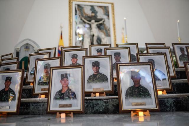 Portraits of some of the 69 soldiers and police officers who died in an Air Force Hercules accident are displayed during a religious ceremony in Bogota on March 27, 2026. The death toll in one of Colombia's worst air accidents in recent years rose to at least 69, according to an updated tally on March 24, as the government faulted a "junk" aircraft donated by the United States. (Photo by Sergio Yate / AFP)