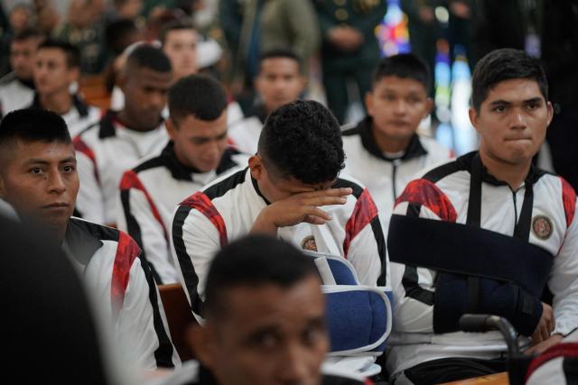 A survivor of the Air Force Hercules accident weeps during a religious ceremony in Bogota on March 27, 2026. The death toll in one of Colombia's worst air accidents in recent years rose to at least 69, according to an updated tally on March 24, as the government faulted a "junk" aircraft donated by the United States. (Photo by Sergio Yate / AFP)