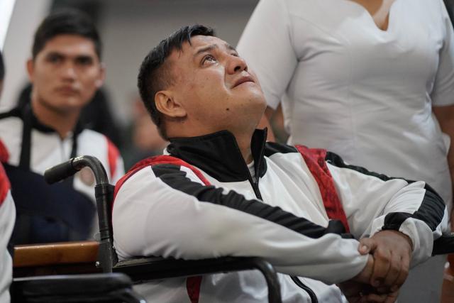 A survivor of the Air Force Hercules accident weeps during a religious ceremony in Bogota on March 27, 2026. The death toll in one of Colombia's worst air accidents in recent years rose to at least 69, according to an updated tally on March 24, as the government faulted a "junk" aircraft donated by the United States. (Photo by Sergio Yate / AFP)