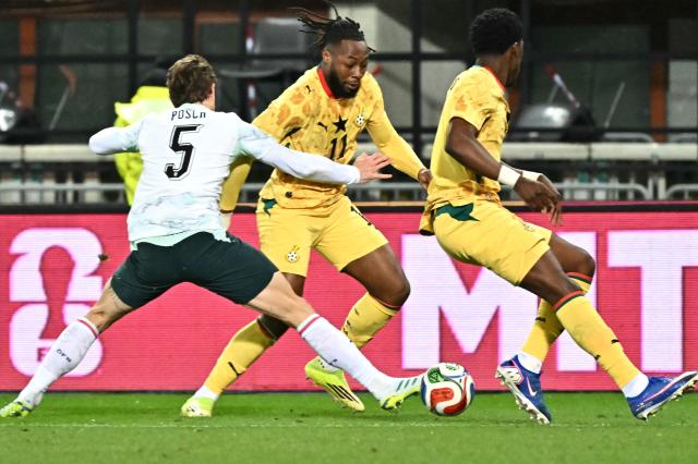 Austria's defender #05 Stefan Posch (L) and Ghana's forward #11 Antoine Semenyo (C) vie for the ball during the friendly football match Austria vs Ghana in Vienna, Austria, on March 27, 2026. (Photo by Joe Klamar / AFP)