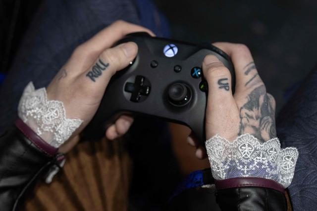 A gamer with 'up' and 'roll' tattooed on his thumb plays a video game during DreamHack 2026 gaming convention at the NEC in Birmingham, central England on March 27, 2026. (Photo by Oli SCARFF / AFP)