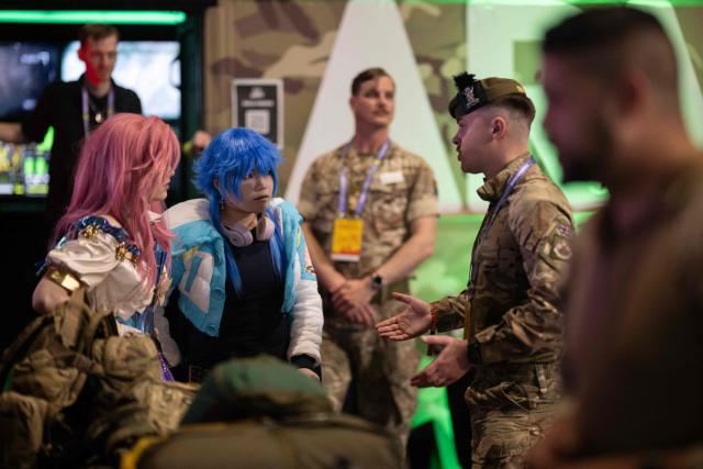 A member of the British Army's public engagement team speaks with cosplayers at the DreamHack 2026 gaming convention at the NEC in Birmingham, central England on March 27, 2026. (Photo by Oli SCARFF / AFP)