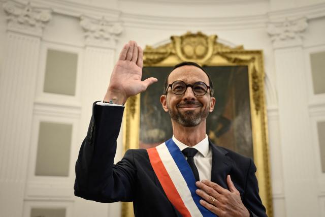 Pau's new Mayor Jerome Marbot waves after receiving the tricolour mayoral sash during his installation as Mayor of Pau at the City Hall (Hotel de Ville) of Pau, south-western France, on March 27, 2026. Marbot, a public and environmental law attorney, defeated outgoing MoDem leader Francois Bayrou by 344 votes in the second round of municipal elections on March 22. (Photo by Philippe LOPEZ / AFP)