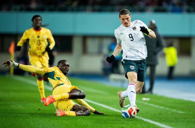 Ghana's midfielder #04 Jonas Adjetey (C) and Austria's forward #09 Marcel Sabitzer (R) vie for the ball during the friendly football match Austria vs Ghana in Vienna, Austria, on March 27, 2026. (Photo by GEORG HOCHMUTH / APA / AFP) / Austria OUT
