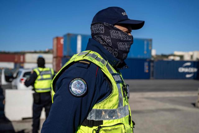 A French customs' officer patrols during the visit of France's junior Minister for Public Accounts at the Grand Port Maritime of Marseille, southeastern France on March 27, 2026.  (Photo by MIGUEL MEDINA / AFP)