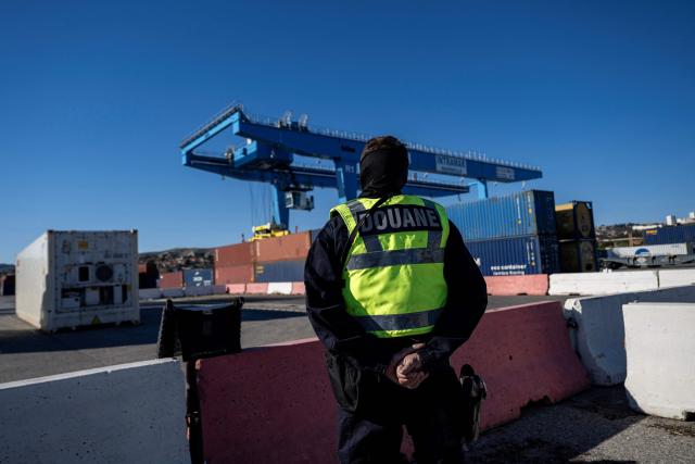 A French customs' officer patrols during the visit of France's junior Minister for Public Accounts at the Grand Port Maritime of Marseille, southeastern France on March 27, 2026.  (Photo by MIGUEL MEDINA / AFP)