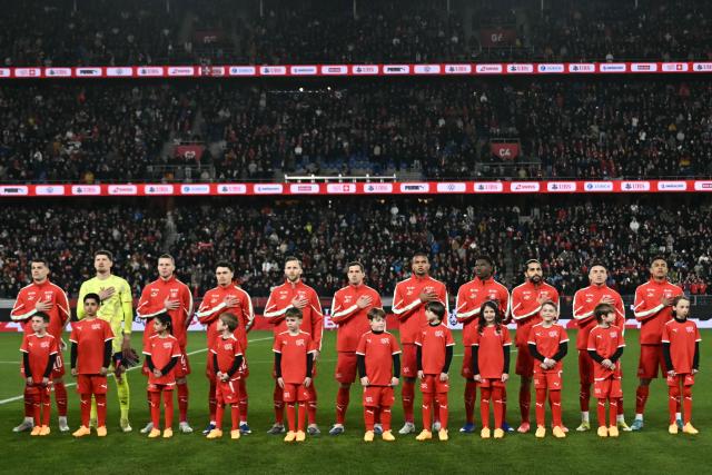 Switzerland's starting squad stands on the pitch for national anthems ahead of the start of the international friendly football match between Switzerland and Germany at St.Jakob-Park in Basel, Switzerland on March 27, 2026. (Photo by Fabrice COFFRINI / AFP)