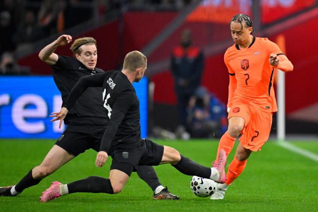 Netherlands' midfielder #07 Xavi Simons (R) fights for the ball with Norway's defender #14 Julian Ryerson during a friendly football match between the Netherlands and Norway at the Johan Cruijff Arena in Amsterdam on March 27, 2026. (Photo by JOHN THYS / AFP)