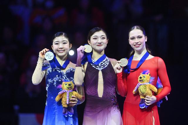(L-R) Silver-medal winner Japan's Mone Chiba, gold-medal winner Japan's Kaori Sakamoto and bronze-medal winner Belgium's Nina Pinzarrone celebrate with their medals on the podium after the women's free skating program of the 2026 ISU Figure Skating World Championships in Prague, Czech Republic on March 27, 2026. (Photo by Michal Cizek / AFP)