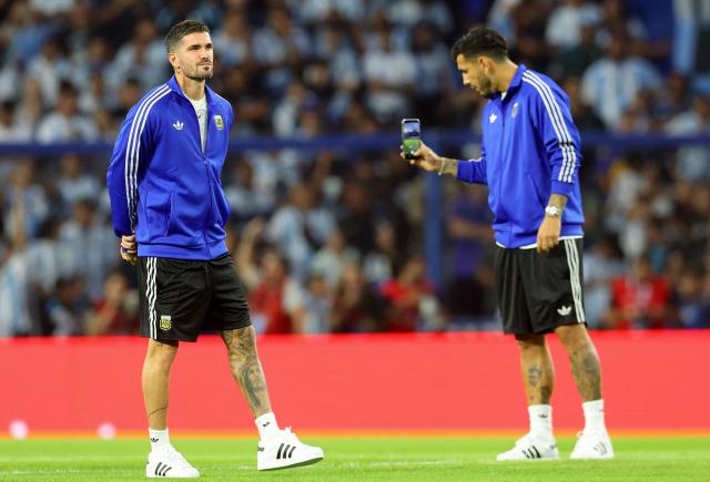 Argentina's midfielder Leandro Paredes (R) takes a photo of his teammate midfielder Rodrigo De Paul during a pre-match inspection ahead of a friendly football match between Argentina and Mauritania at La Bombonera stadium in Buenos Aires on March 27, 2026. (Photo by ALEJANDRO PAGNI / AFP)