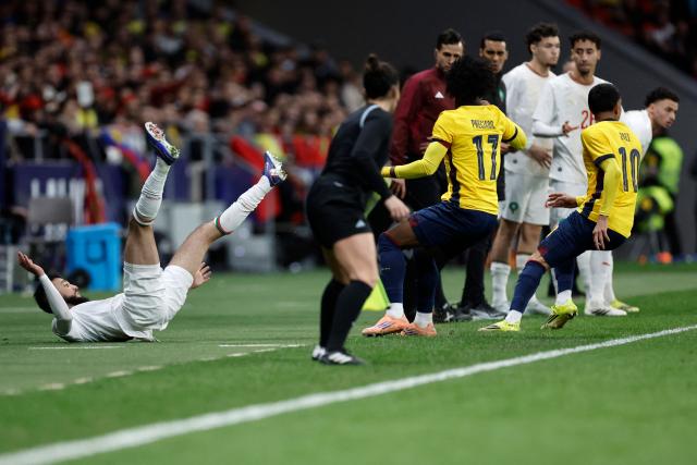 TOPSHOT - Morocco's defender #03 Noussair Mazraoui (L) goes down by the touchline during the international friendly football match between Morocco and Ecuador at Metropolitano Stadium in Madrid on March 27, 2026. (Photo by Oscar DEL POZO / AFP)