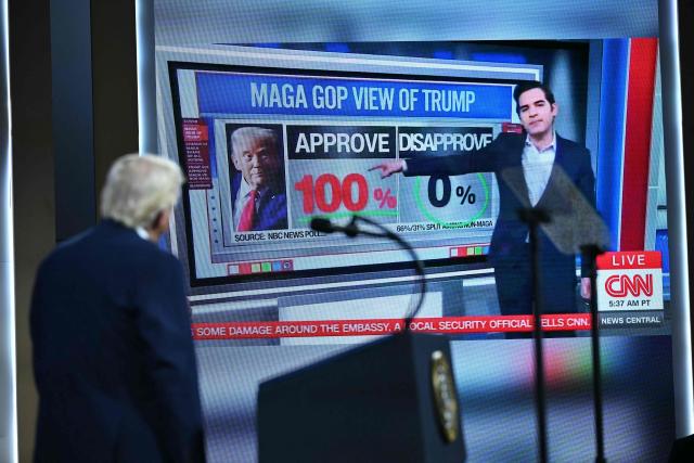 US President Donald Trump shows a clip from a CNN report as he speaks during the Future Investment Initiative (FII) Summit in Miami Beach, Florida, on March 27, 2026. (Photo by Mandel NGAN / AFP)