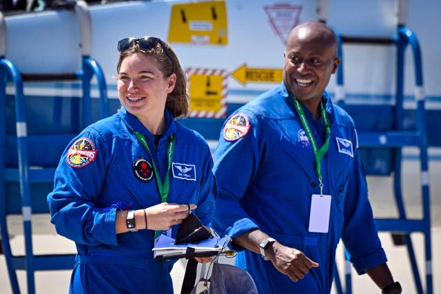 Canadian Space Agency astronaut Jenni Gibbons (L) and NASA astronaut Andre Douglas, backup crew members for the Artemis II mission, arrive for a welcome ceremony ahead of the Artemis II April 1 launch at Kennedy Space Center in Florida on March 27, 2026. NASA astronauts assigned to the Artemis II mission arrive at Kennedy Space Center in Florida on March 27, 2026, to begin final pre-launch preparations for the first crewed lunar flyby in the Artemis program. The journey, set to last around 10 days, will take the astronauts on a loop around the Moon, though they will not land on its surface. The crew comprises the first woman, the first person of color and the first non-American to take part in such a journey. (Photo by Miguel J Rodriguez Carrillo / AFP)