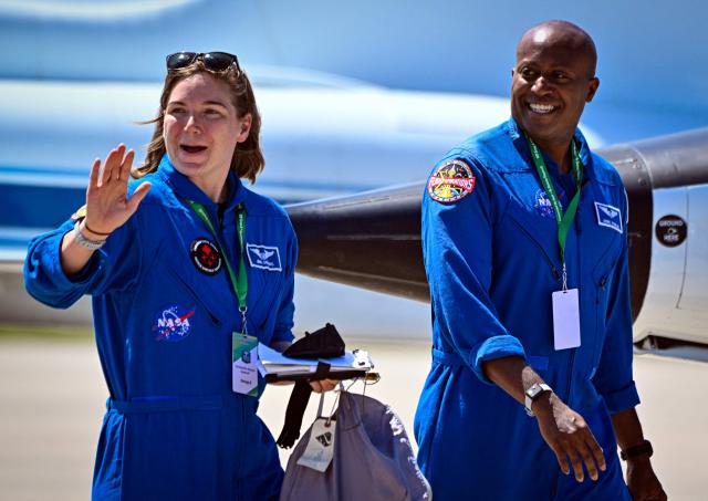 Canadian Space Agency astronaut Jenni Gibbons (L) and NASA astronaut Andre Douglas, backup crew members for the Artemis II mission, arrive for a welcome ceremony ahead of the Artemis II April 1 launch at Kennedy Space Center in Florida on March 27, 2026. NASA astronauts assigned to the Artemis II mission arrive at Kennedy Space Center in Florida on March 27, 2026, to begin final pre-launch preparations for the first crewed lunar flyby in the Artemis program. The journey, set to last around 10 days, will take the astronauts on a loop around the Moon, though they will not land on its surface. The crew comprises the first woman, the first person of color and the first non-American to take part in such a journey. (Photo by Miguel J Rodriguez Carrillo / AFP)