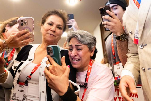 Iranian attendees react to participating in a video call with Iranian political activist Reza Pahlavi during the Conservative Political Action Conference (CPAC) in Grapevine, Texas, on March 27, 2026. American conservatives converge on Texas this week for what organizers bill as their largest and most influential gathering, with the Iran war and fears of a punishing midterm election cycle heightening the stakes. (Photo by Leandro Lozada / AFP)