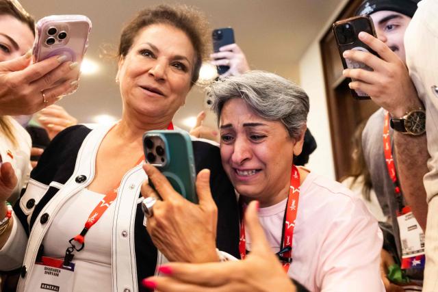 Iranian attendees react to participating in a video call with Iranian political activist Reza Pahlavi during the Conservative Political Action Conference (CPAC) in Grapevine, Texas, on March 27, 2026. American conservatives converge on Texas this week for what organizers bill as their largest and most influential gathering, with the Iran war and fears of a punishing midterm election cycle heightening the stakes. (Photo by Leandro Lozada / AFP)