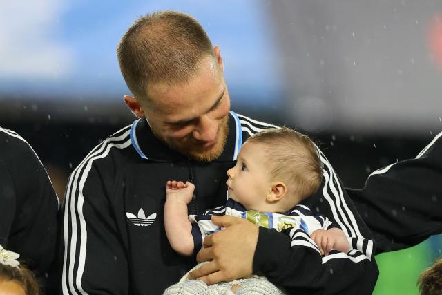 Argentina's midfielder #20 Alexis Mac Allister carries his baby daughter before a friendly football match between Argentina and Mauritania at La Bombonera stadium in Buenos Aires on March 27, 2026. (Photo by ALEJANDRO PAGNI / AFP)