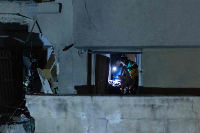People search for their belongings in a building damaged by a strike in Tel Aviv on March 28, 2026. On the evening of March 27, the Israeli army reported missiles fired by Iran at Israel. (Photo by Ilia YEFIMOVICH / AFP) / 