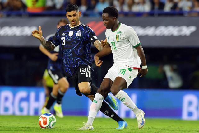 Argentina's defender #13 Cristian Romero and Mauritania's forward #78 Djeidi Gassama fight for the ball during a friendly football match between Argentina and Mauritania at La Bombonera stadium in Buenos Aires on March 27, 2026. (Photo by ALEJANDRO PAGNI / AFP)