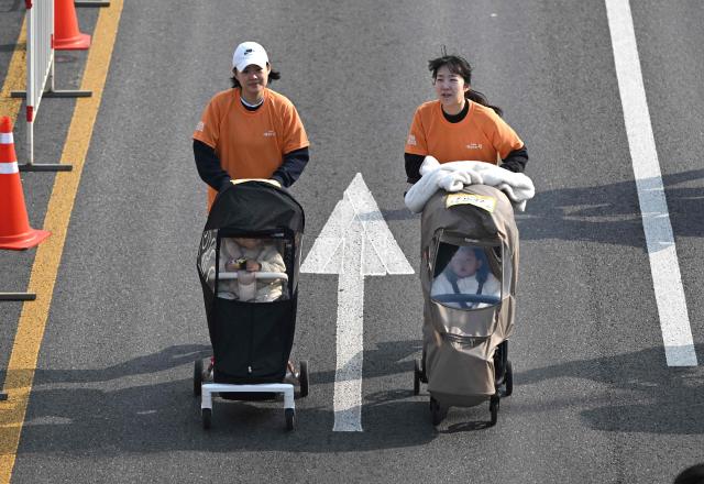 Participants run with strollers during the 2026 Seoul Stroller Run, a family-focused 8km event hosted by the Seoul Metropolitan Government, in central Seoul on March 28, 2026. (Photo by Jung Yeon-je / AFP)