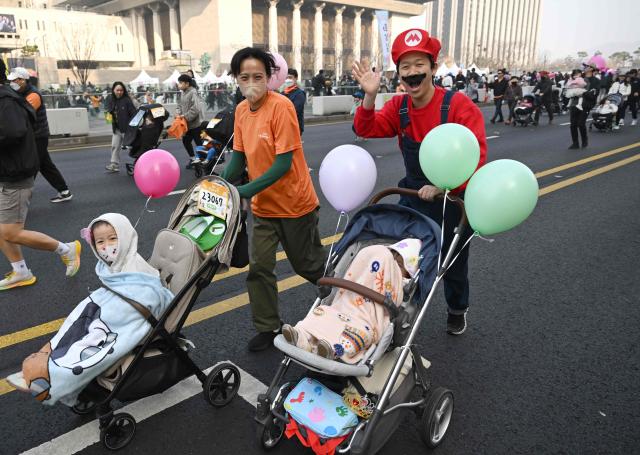 Participants run with strollers during the 2026 Seoul Stroller Run, a family-focused 8km event hosted by the Seoul Metropolitan Government, in central Seoul on March 28, 2026. (Photo by Jung Yeon-je / AFP)