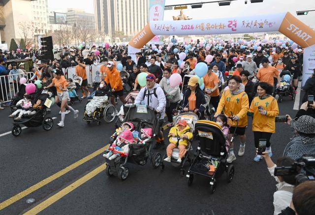 Participants run with strollers during the 2026 Seoul Stroller Run, a family-focused 8km event hosted by the Seoul Metropolitan Government, in central Seoul on March 28, 2026. (Photo by Jung Yeon-je / AFP)