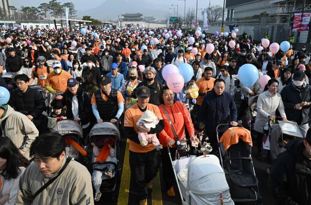 Participants push strollers during the 2026 Seoul Stroller Run, a family-focused 8km event hosted by the Seoul Metropolitan Government, in central Seoul on March 28, 2026. (Photo by Jung Yeon-je / AFP)