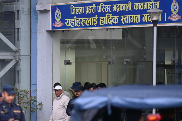 Nepal's former prime minister KP Sharma Oli (2nd L, in grey) is escorted by police as he is brought to the hospital following his arrest in Kathmandu on Mach 28, 2026. Nepal's former prime minister KP Sharma Oli and ex-home minister Ramesh Lekhak were arrested March 28 over their alleged involvement in a deadly crackdown on protestors in September, police said. (Photo by Prakash Mathema / AFP)