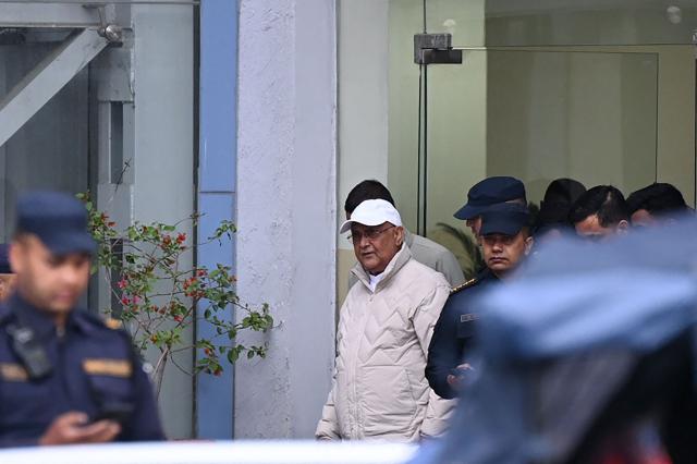 Nepal's former prime minister KP Sharma Oli (C, in grey) is escorted by police as he is brought to the hospital following his arrest in Kathmandu on Mach 28, 2026. Nepal's former prime minister KP Sharma Oli and ex-home minister Ramesh Lekhak were arrested March 28 over their alleged involvement in a deadly crackdown on protestors in September, police said. (Photo by Prakash Mathema / AFP)
