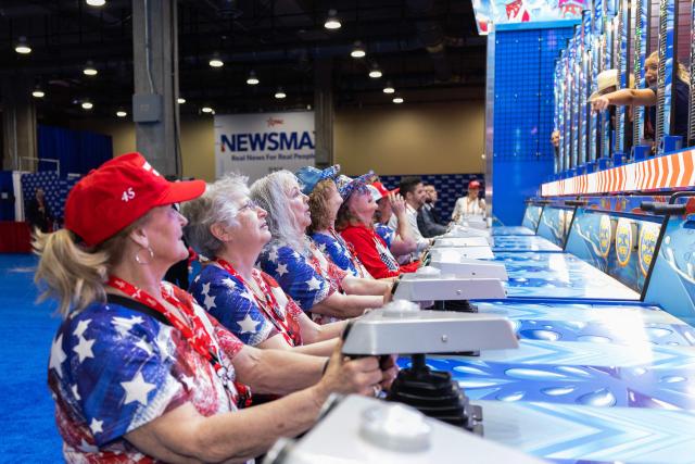 A group of women clad in American-themed attire play interactive games during the Conservative Political Action Conference (CPAC) in Grapevine, Texas, on March 27, 2026. American conservatives converge on Texas this week for what organizers bill as their largest and most influential gathering, with the Iran war and fears of a punishing midterm election cycle heightening the stakes. (Photo by Leandro Lozada / AFP)