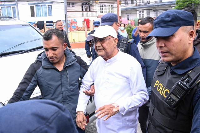 Nepal's former prime minister KP Sharma Oli (C) is escorted by police as he is brought to the hospital following his arrest in Kathmandu on March 28, 2026. Nepal's former prime minister KP Sharma Oli and ex-home minister Ramesh Lekhak were arrested March 28 over their alleged involvement in a deadly crackdown on protestors in September, police said. (Photo by PRAKASH MATHEMA / AFP)