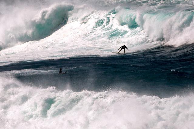 Surfers catch large waves breaking at Bondi Beach in Sydney on March 28, 2026 as large swells and high winds create hazardous surf conditions along the south-east coast of Australia. (Photo by DAVID GRAY / AFP)