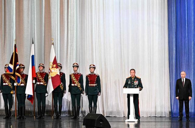 In this pool photograph distributed by the Russian state agency Sputnik, the Director of the Federal Service of National Guard Troops - Commander-in-Chief of the National Guard Troops of the Russian Federation (Rosgvardia) Viktor Zolotov (1nd-R) speaks as Russian President Vladimir Putin looks on during a gala evening in the State Kremlin Palace in Moscow dedicated to the 10th anniversary of the Rosgvardia, on March 27, 2026. (Photo by Sergei BOBYLYOV / POOL / AFP)