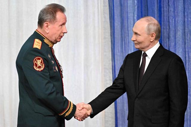 In this pool photograph distributed by the Russian state agency Sputnik, Russian President Vladimir Putin shakes hands with the Director of the Federal Service of National Guard Troops - Commander-in-Chief of the National Guard Troops of the Russian Federation (Rosgvardia) Viktor Zolotov (L) during a gala evening in the State Kremlin Palace in Moscow dedicated to the 10th anniversary of the Rosgvardia, on March 27, 2026. (Photo by Sergei BOBYLYOV / POOL / AFP)