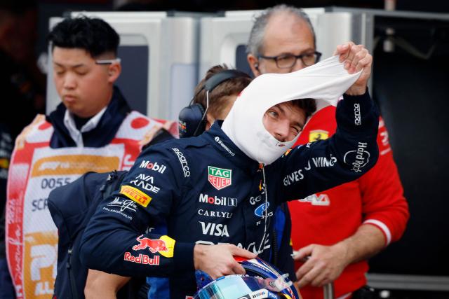 Red Bull Racing's Dutch driver Max Verstappen takes off his balaclava in the pits during the qualifying session ahead of the Formula One Japanese Grand Prix at the Suzuka circuit in Suzuka, Mie prefecture on March 28, 2026. (Photo by FRANCK ROBICHON / POOL / AFP)