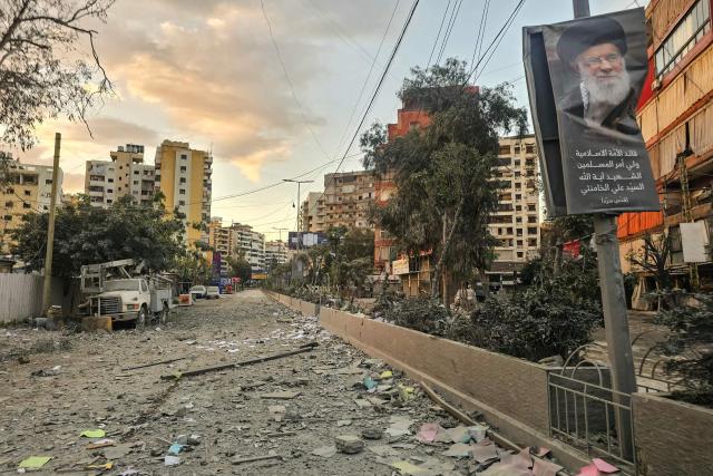 A photograph shows a portrait of Iran’s slain supreme leader Ayatollah Ali Khamenei along a street covered with debris following an Israeli airstrike in Beirut’s southern suburbs on March 28, 2026. Israel's military renewed its attacks on Beirut's southern suburbs on March 27, saying it was targeting Hezbollah infrastructure, as the Iran-backed group said the foes had clashed directly in the country's south. (Photo by AFP) / 