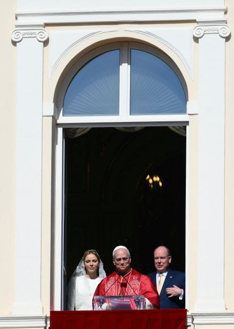 Pope Leo XIV  gives a speech from the balcony next to Prince's Albert II of Monaco (R) and Princess Charlene of Monaco at the Prince's Palace of Monaco in Monte Carlo, Monaco, on March 28, 2026. Pope Leo XIV heads to the Mediterranean principality of Monaco on the French Riviera that is the pontiff's surprise pick for the first western European trip of his papacy. The US-born pope, a former missionary critical of the wealthy elite, will helicopter in for a day in the world's second-smallest state, best known for its casinos, luxury yachts and Michelin-starred dining. (Photo by Marco BERTORELLO / AFP)