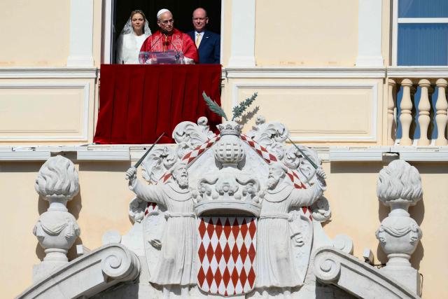 Pope Leo XIV  gives a speech from the balcony next to Prince's Albert II of Monaco (R) and Princess Charlene of Monaco at the Prince's Palace of Monaco in Monte Carlo, Monaco, on March 28, 2026. Pope Leo XIV heads to the Mediterranean principality of Monaco on the French Riviera that is the pontiff's surprise pick for the first western European trip of his papacy. The US-born pope, a former missionary critical of the wealthy elite, will helicopter in for a day in the world's second-smallest state, best known for its casinos, luxury yachts and Michelin-starred dining. (Photo by Marco BERTORELLO / AFP)
