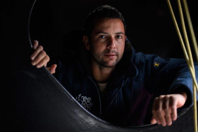 (FILES) French skipper Guirec Soudee poses aboard his Imoca 60 "Freelance.com" at the Vendee Globe village ahead of the 10th edition of the Vendee Globe around the world monohull solo sailing race, in Les Sables-d'Olonne, western France on November 7, 2024. On Mrach 28, 2026, French skipper Guirec Soudée smashed the record for sailing around the world in the opposite direction (from east to west, against prevailing winds and currents) aboard the MACSF maxi-trimaran in 94 days, 21 hours, and 58 minutes. (Photo by Loic VENANCE / AFP)