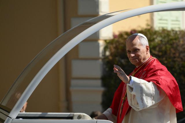 Pope Leo XIV waves from his Papamobile as he arrives to meet with members of the catholic community in the Cathedral of the Immaculate Conception in Monte Carlo, Monaco, on March 28, 2026. Pope Leo XIV heads to the Mediterranean principality of Monaco on the French Riviera that is the pontiff's surprise pick for the first western European trip of his papacy. The US-born pope, a former missionary critical of the wealthy elite, will helicopter in for a day in the world's second-smallest state, best known for its casinos, luxury yachts and Michelin-starred dining. (Photo by Marco BERTORELLO / AFP)