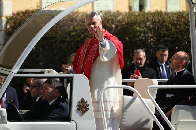 Pope Leo XIV waves from his Papamobile as he arrives to meet with members of the catholic community in the Cathedral of the Immaculate Conception in Monte Carlo, Monaco, on March 28, 2026. Pope Leo XIV heads to the Mediterranean principality of Monaco on the French Riviera that is the pontiff's surprise pick for the first western European trip of his papacy. The US-born pope, a former missionary critical of the wealthy elite, will helicopter in for a day in the world's second-smallest state, best known for its casinos, luxury yachts and Michelin-starred dining. (Photo by Marco BERTORELLO / AFP)