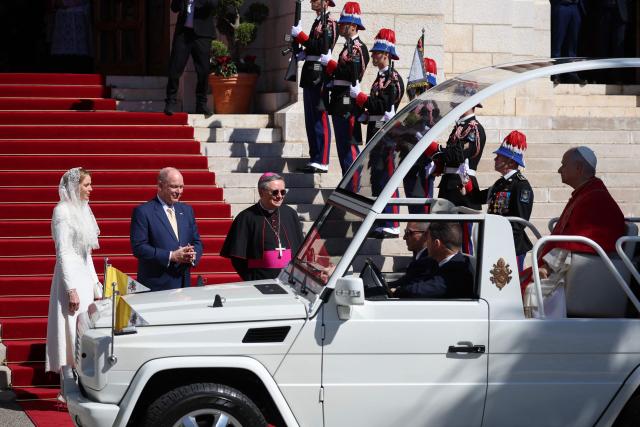 Prince's Albert II of Monaco and princess Charlene De Monaco watch Pope Leo XIV as he arrives to meet with members of the catholic community in the Cathedral of the Immaculate Conception in Monte Carlo, Monaco, on March 28, 2026. Pope Leo XIV heads to the Mediterranean principality of Monaco on the French Riviera that is the pontiff's surprise pick for the first western European trip of his papacy. The US-born pope, a former missionary critical of the wealthy elite, will helicopter in for a day in the world's second-smallest state, best known for its casinos, luxury yachts and Michelin-starred dining. (Photo by Valery HACHE / AFP)