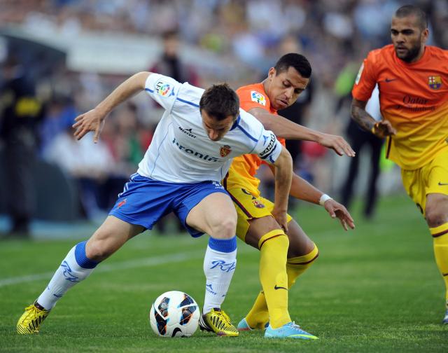 (FILES) Barcelona's Chiliean forward Alexis Sanchez (R) vies with Zaragoza's midfielder Juan Carlos (L) during the Spanish League football match between Real Zaragoza and FC Barcelona on April 14, 2013 at La Romareda stadium in Zaragoza. Thirty years after winning the UEFA Cup Winners' Cup (against Arsenal), Zaragoza is fighting to avoid relegation to Spain's third division. (Photo by Lluis GENE / AFP)