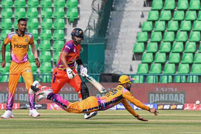 Peshawar Zalmi's Pakistani cricket player Mohammad Haris (R) unsuccessfully attempts to run out Rawalpindiz's Pakistani cricket player Yasir Khan (C) during the Pakistan Super League (PSL) T20 match between Peshawar Zalmi and Rawalpindiz at the Gaddafi Cricket Stadium in Lahore on March 28, 2026. (Photo by Arif ALI / AFP)