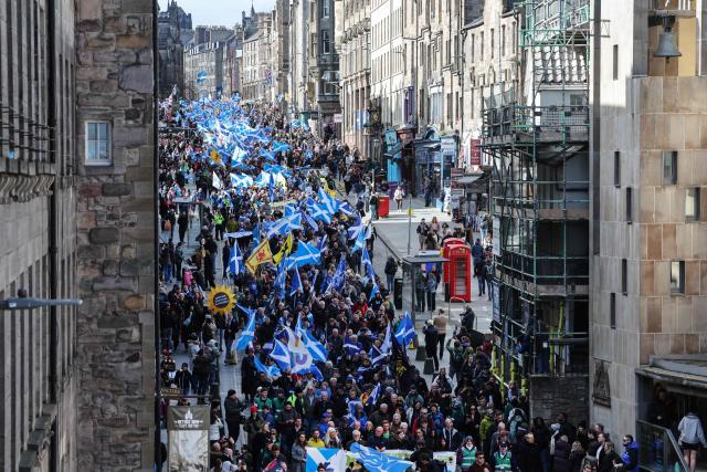 People wave Scottish flags and hold placards as they march in support of Scottish independence in Edinburgh on March 28, 2026. (Photo by Robert Perry / AFP)