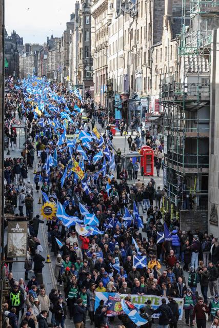 People wave Scottish flags and hold placards as they march in support of Scottish independence in Edinburgh on March 28, 2026. (Photo by Robert Perry / AFP)